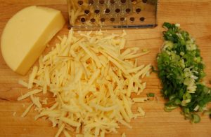 Chopped green onion and grated smoked gouda ready to add to grits.