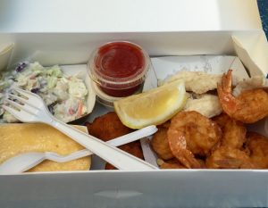 Lunch at the Star Fish Co. Fried gulf shrimp, sautéed grouper, cheese grits, hush puppies and Cole slaw. 